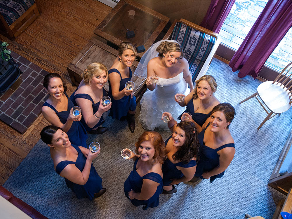 Bride and bridesmaids raising classes and toasting on the wedding day in western Maine