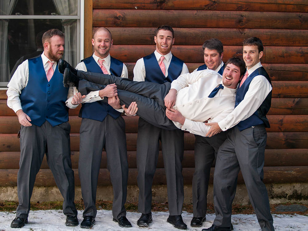 Groom and groomsmen on wedding day in front of a cabin in The Forks, Maine