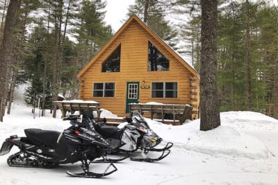 Northwoods cabin in winter with snowmobiles