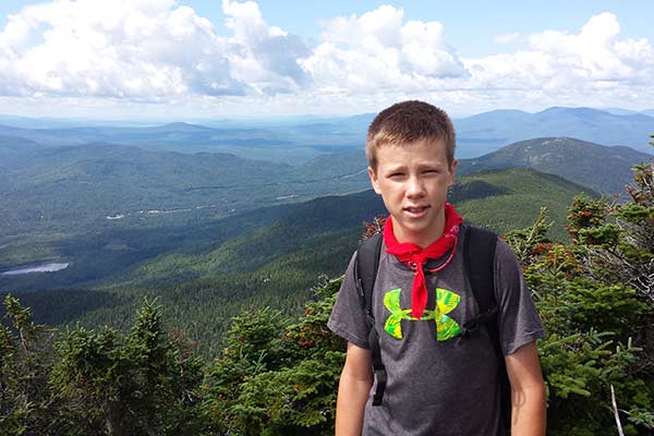 Kid on top of a mountain in Maine on a family reunion 