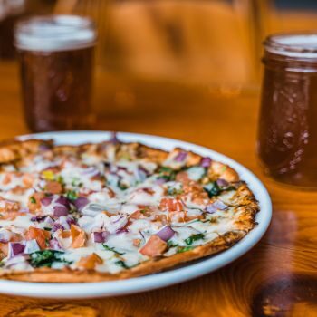 Kennebec River Brewery Pizza Night special, featuring a pizza and two beers.