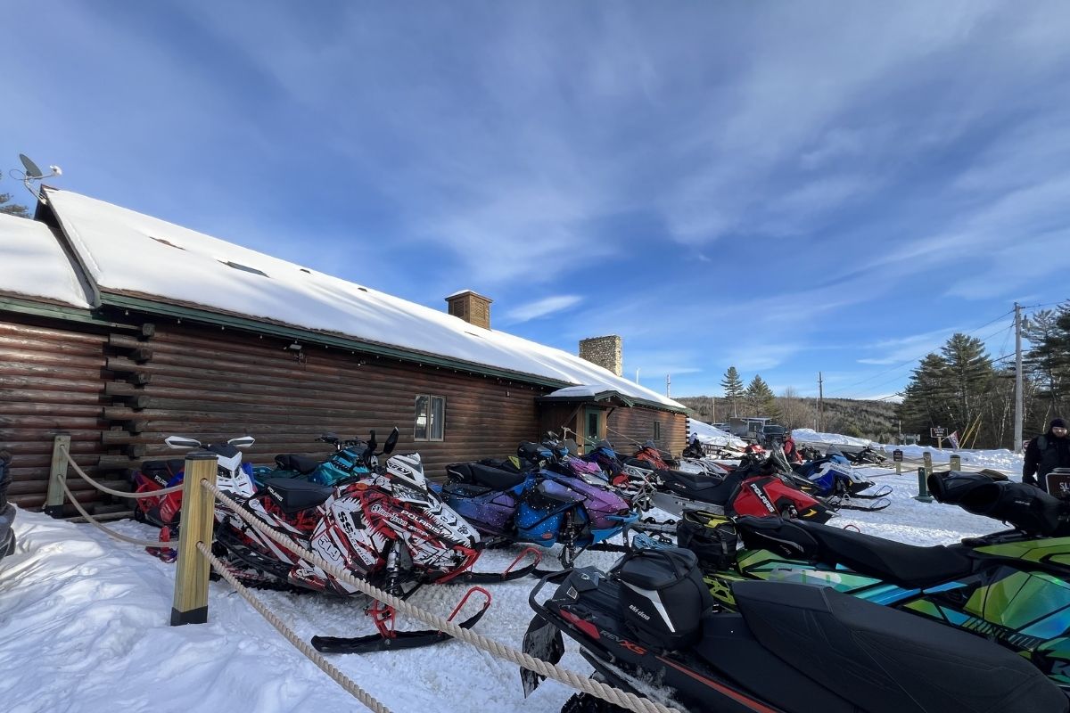Snowmobiles parked in front of Northern outdoors lodge in The Forks, Maine